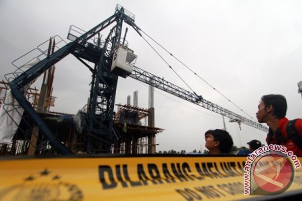 Sejumlah warga melihat dari dekat sebuah tower crane yang ambruk di