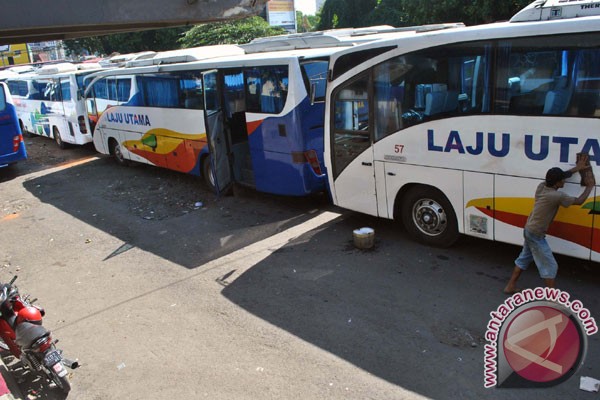 membersihkan busnya di Terminal Bus Antar Kota Antar Provinsi AKAP 