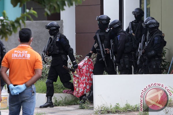 Anggota Tim Densus 88 Antiteror mengamankan sebuah tas yang berisi sebuah senjata laras panjang saat melakukan penggeledahan di salah satu rumah terduga teroris di Batam, Kepulauan Riau, Jumat (5/8/2016). (ANTARA FOTO/M N Kanwa)