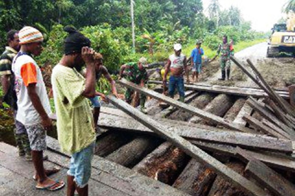 Babinsa Sarmi bersama warga perbaiki jembatan rusak karena banjir