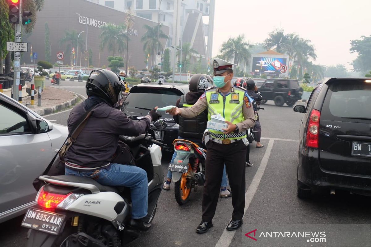 Karhutla Riau - Polisi lalu lintas Pekanbaru kembali bagikan masker pengendara motor terdampak asap