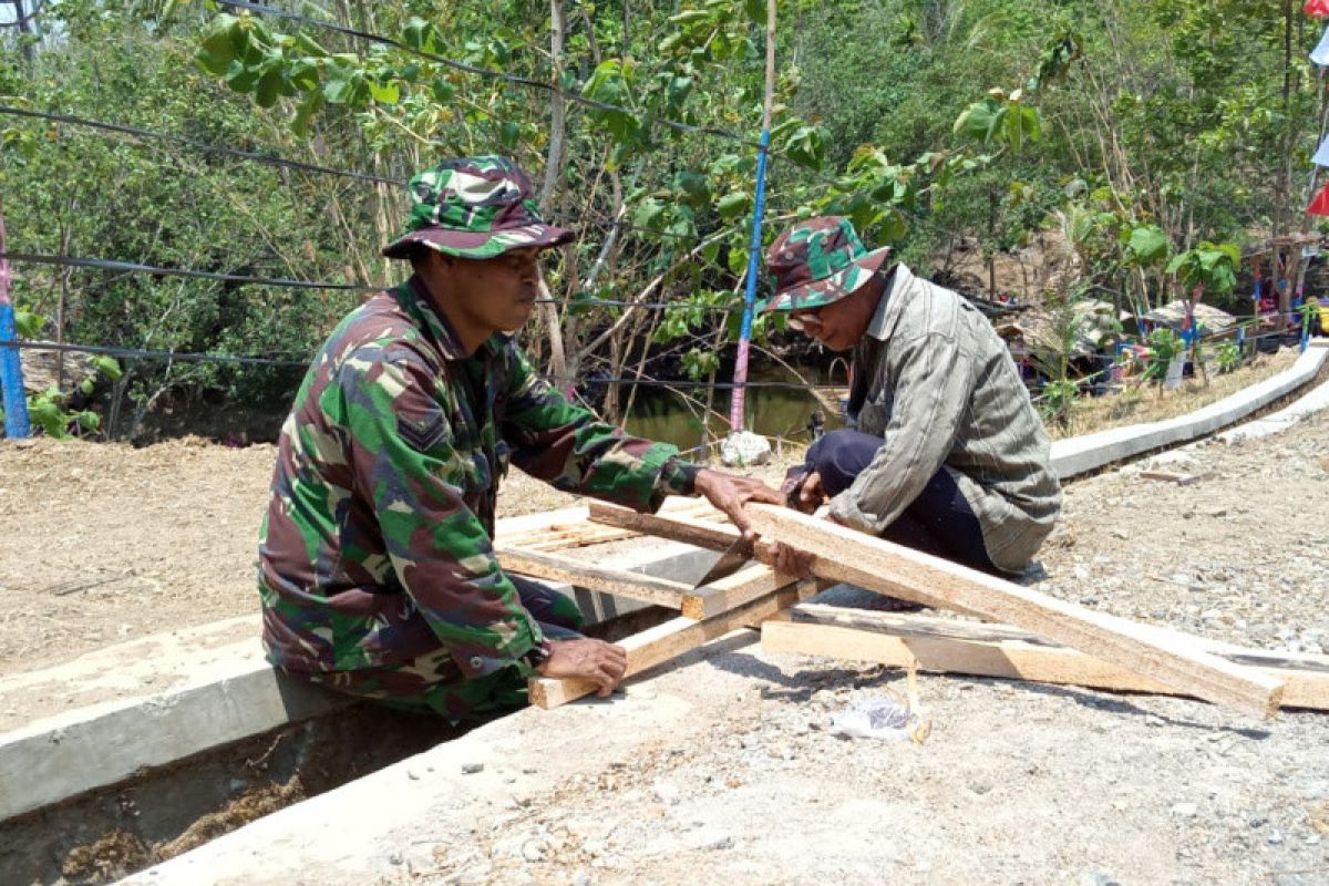 TNI bersama warga bangun jembatan di atas selokan