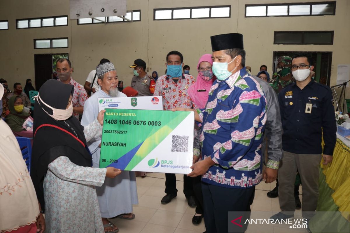 Bupati Siak serahkan BST dan 2.000 Kartu BPJS Ketenagakerjaan bagi warga terdampak COVID-19 di Kandis