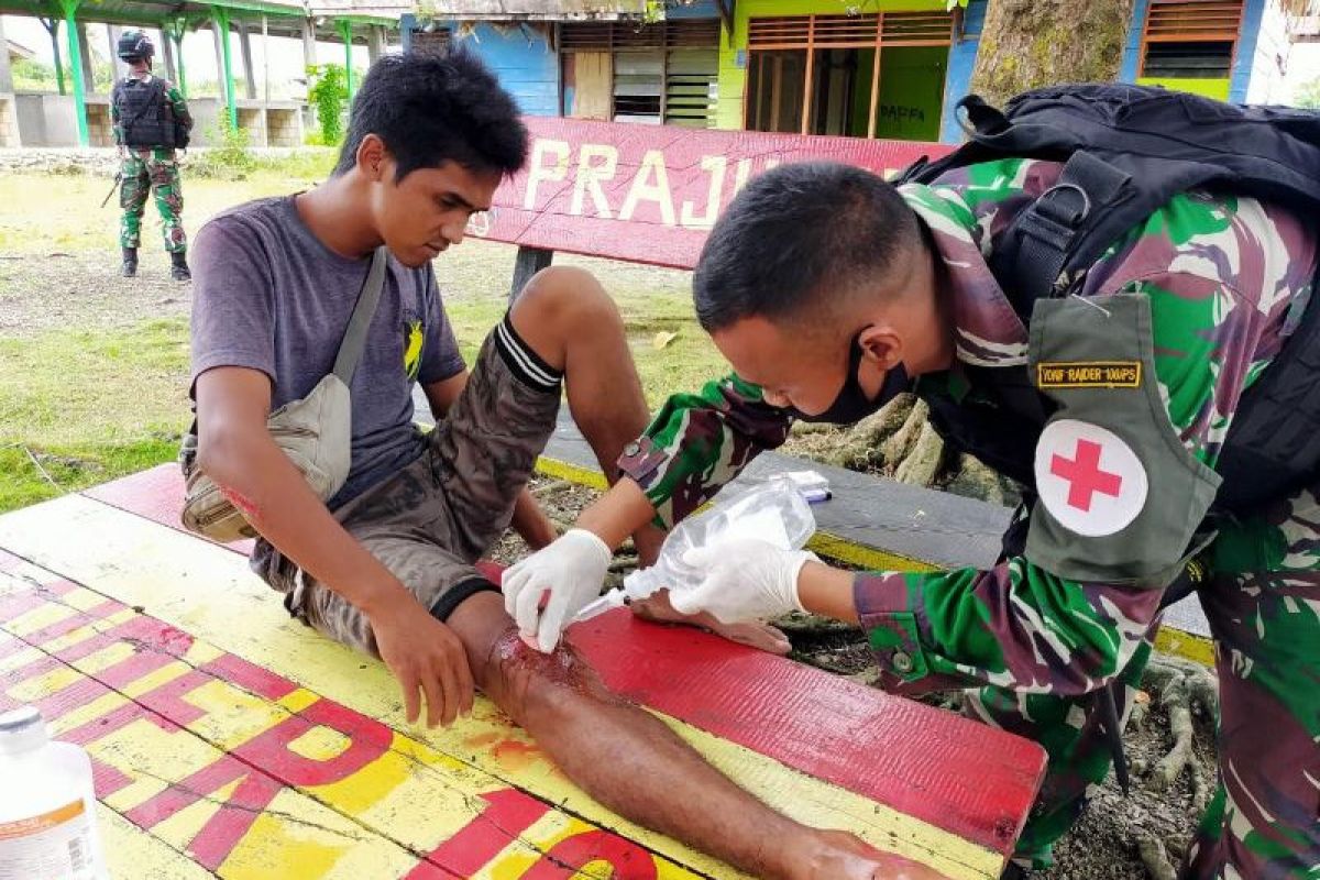 Prajurit Satgas Yonif Raider 100/PS layani pengobatan warga kecelakaan lakalantas