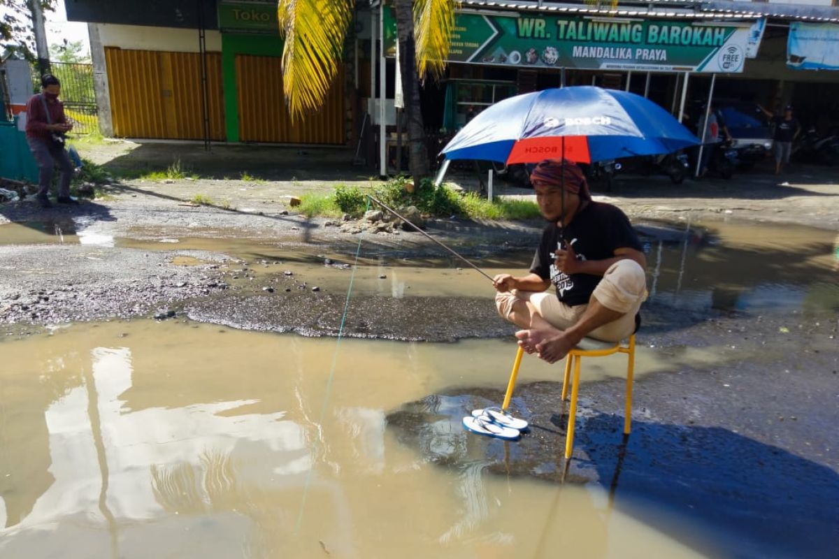 Tak kunjung diperbaiki, seorang warga mandi dan mancing di genangan air Jalan Praya Lombok Tengah (Video)