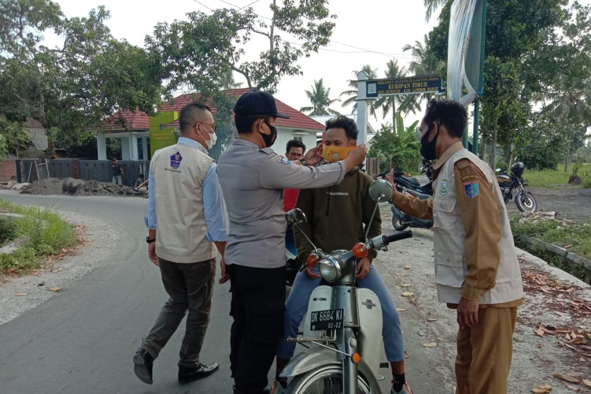 Polsek Kuripan dan Tim PPKM Mikro bagikan masker gratis