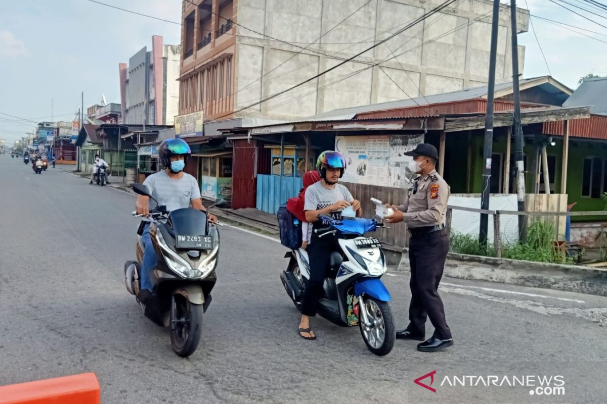 Personel Polres Meranti lakukan pengamanan sambil bagikan masker