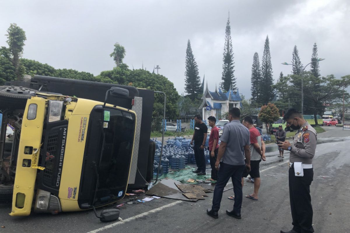 Hilang kendali, truk bermuatan air galon terbalik