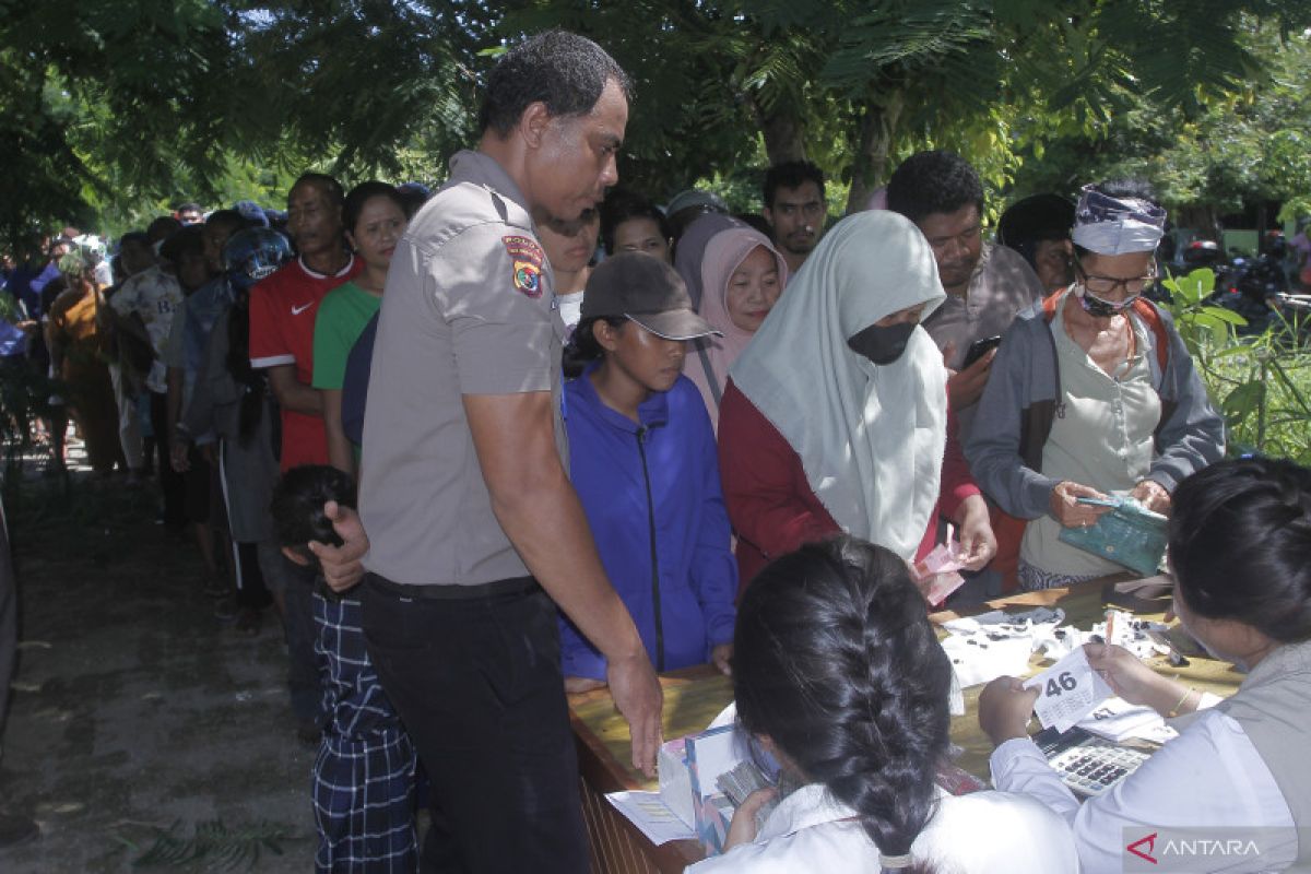 Warga antre sembako dalam pasar murah di Kupang