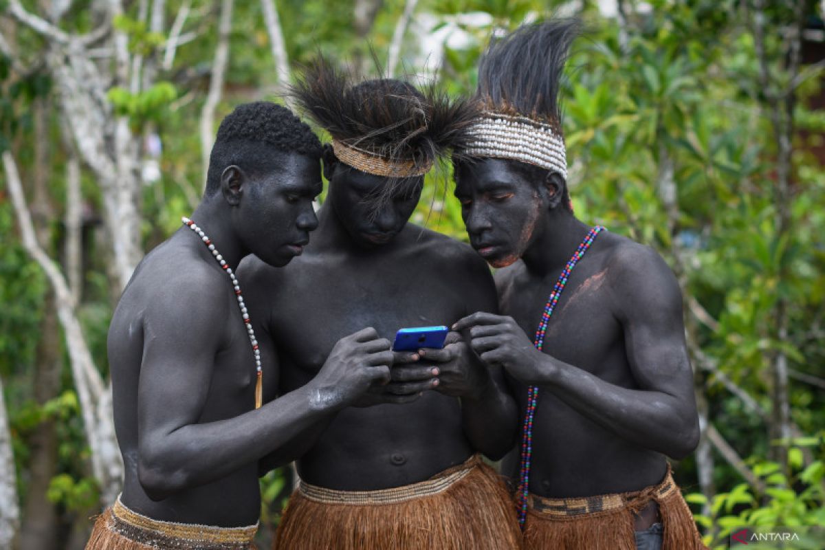Sejumlah warga Suku Asmat mengoperasikan telepon pintar di Distrik Agats, Kabupaten Asmat, Papua Selatan, Kamis (1/6/2023). Sejak 2019 masyarakat di Agats telah dapat menikmati layanan internet cepat dari fasilitas satelit Palapa Ring Paket Timur yang ditujukan untuk wilayah yang terpencil, terluar dan tertinggal (3T). ANTARA FOTO/Aditya Pradana Putra/foc. (ADITYA PRADANA PUTRA/ADITYA PRADANA PUTRA)