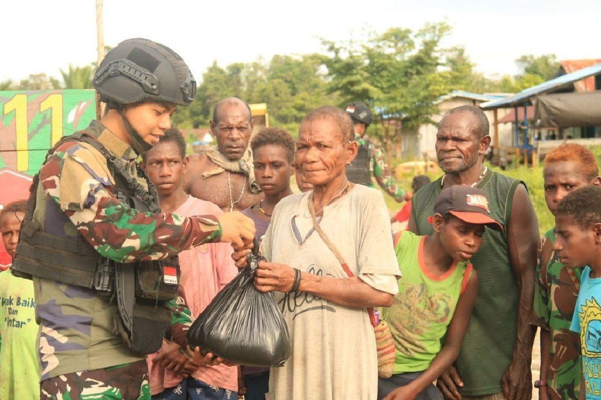 Prajurit Satgas Mobile Yonif  411 Kostrad bagi sembako ke warga Mumugu