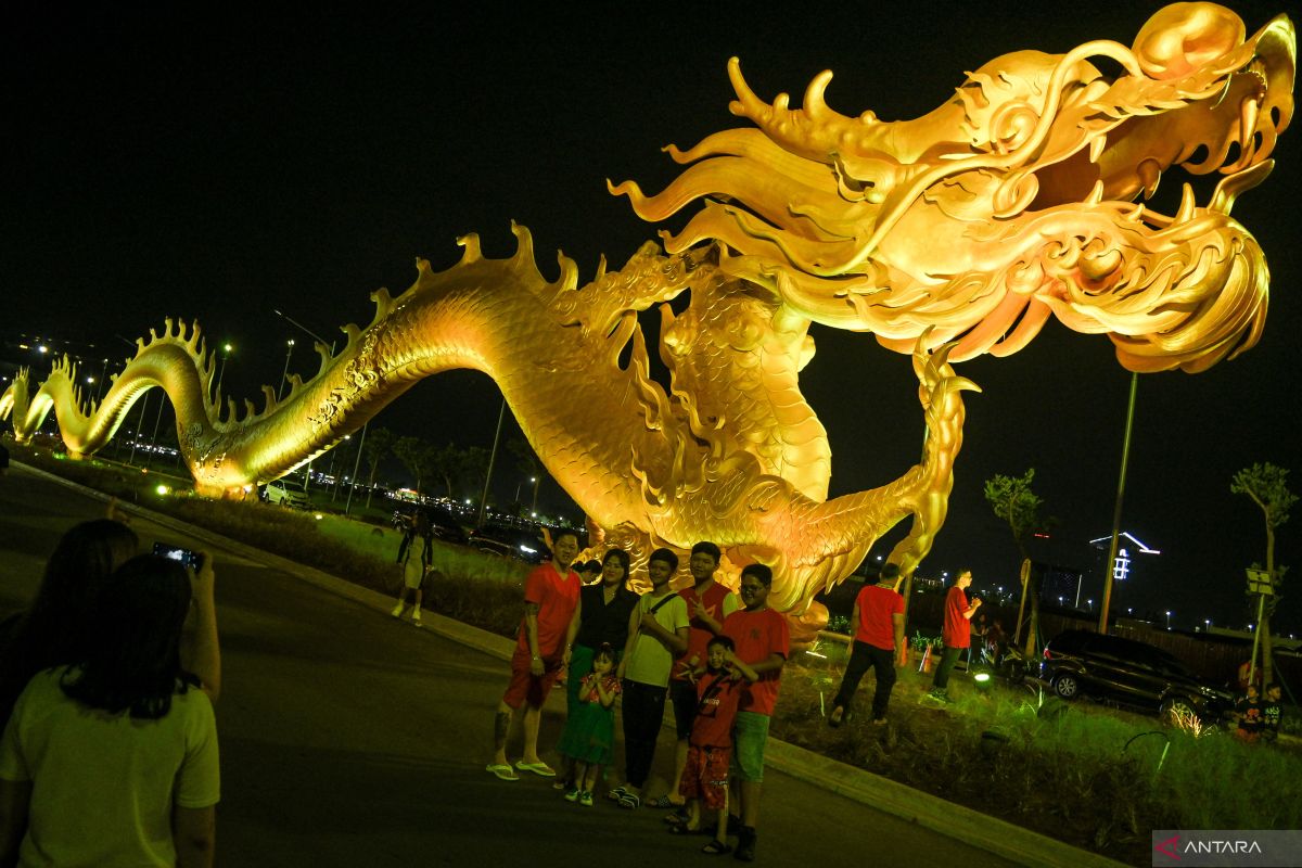 Sejumlah warga berfoto dengan latar belakang patung naga di kawasan Pantai Indah Kapuk (PIK) 2, Kosambi, Kabupaten Tangerang, Banten, Sabtu (10/2/2024). ANTARA FOTO/Sulthony Hasanuddin/YU. total investasi tersebut akan difasilitasi pihak swasta dan tidak ditargetkan menggunakan APBN/APBDJakarta (ANTARA)