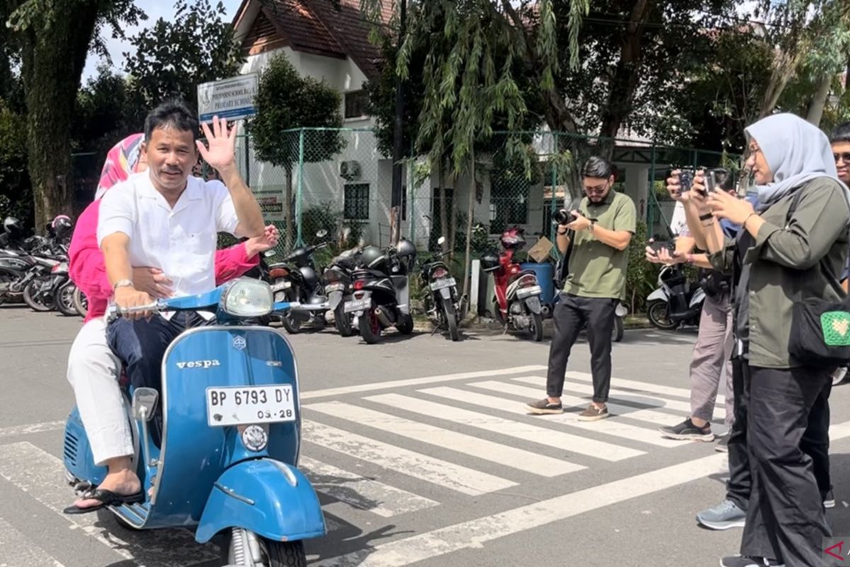 Rudi datang ke TPS naik vespa