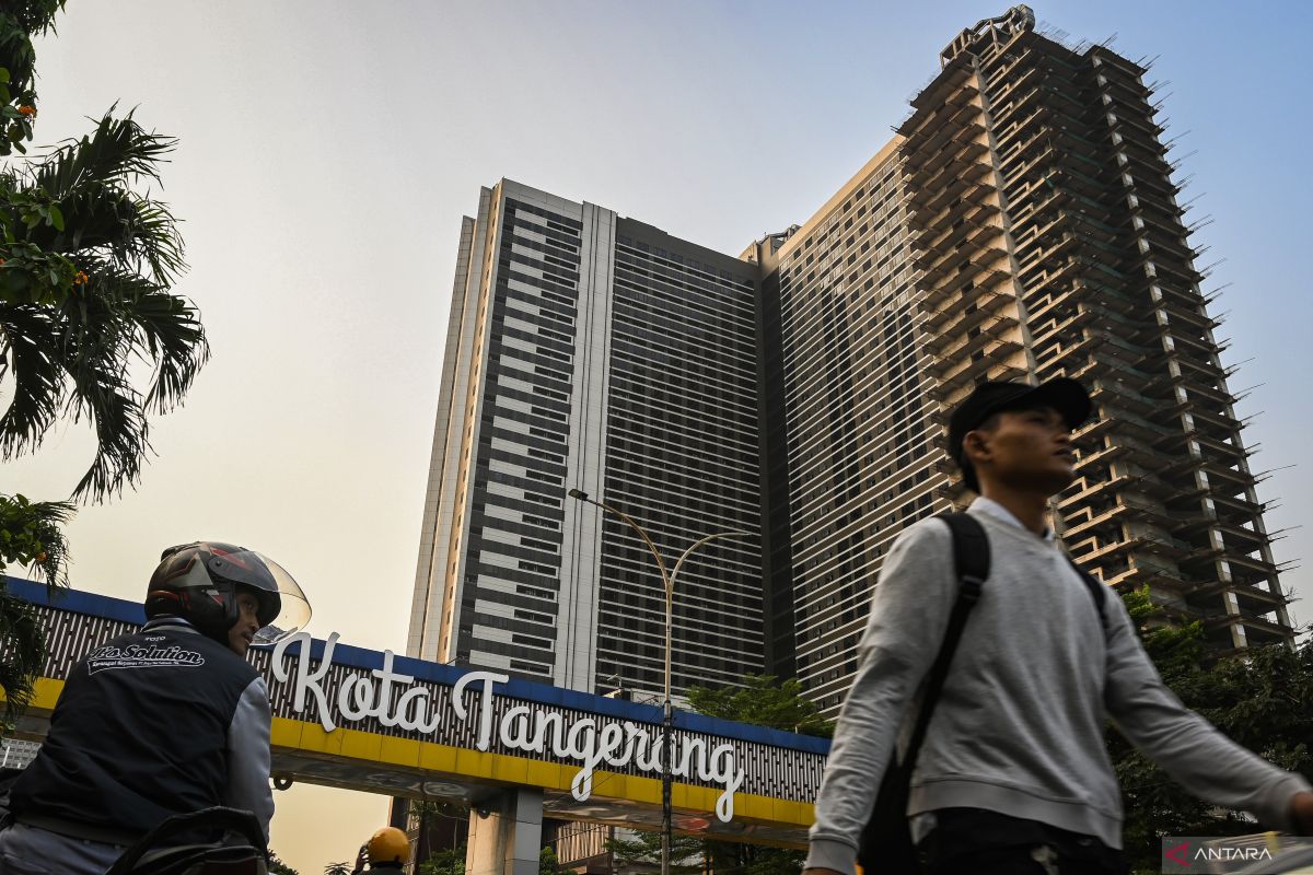 Warga berjalan dengan latar belakang gedung apartemen di kawasan Cikokol, Kota Tangerang, Banten, Senin (12/8/2024). Pemerintah Kota Tangerang mencatat pencapaian realisasi investasi pada Triwulan II tahun 2024 sebesar Rp3,97 triliun dari sebanyak 4.297 proyek yang sebagian proyeknya dari pemerintahan pusat dan mampu menyerap tenaga kerja sebesar 15.459 orang.