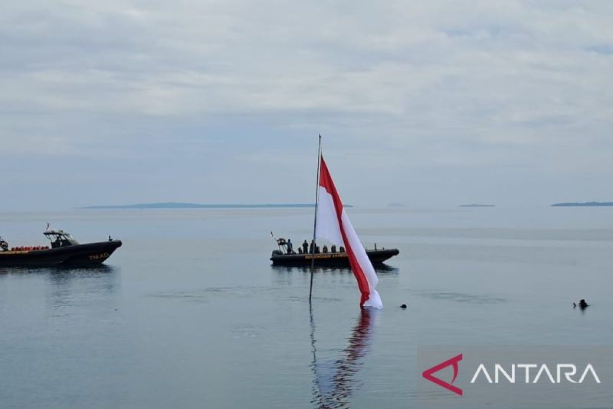 Siswa kibarkan bendera dari dasar laut pantai Malalayang