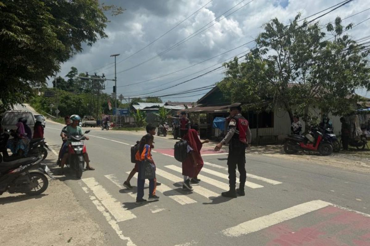 Personel Ditsamapta Polda Kaltara Bantu Anak Sekolah Menyeberang Jalan