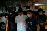 Munarman tiba di Polda Metro dengan mata tertutup dan tangan diborgol