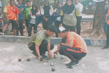 Atlet petanque selesaikan poin akhir dengan alat ukur