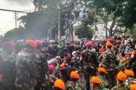 Pasukan TNI duduk di jalan sambil dengan aspirasi demonstran Kwitang