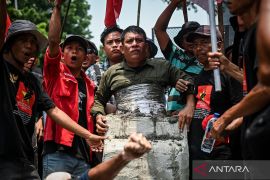 Pengunjuk rasa cor tubuh dalam semen saat aksi Hari Tani Nasional di Jakarta