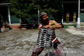 Petugas SPPG Danupayan memakai kostum warok saat mengantar MBG ke sekolah