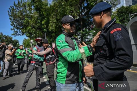 Pengemudi ojek online bagikan bunga mawar saat aksi damai di Jakarta