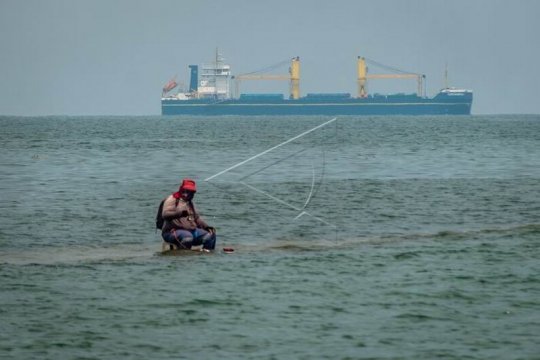 Memancing ikan di atas struktur dam pemecah gelombang Page 1 Small