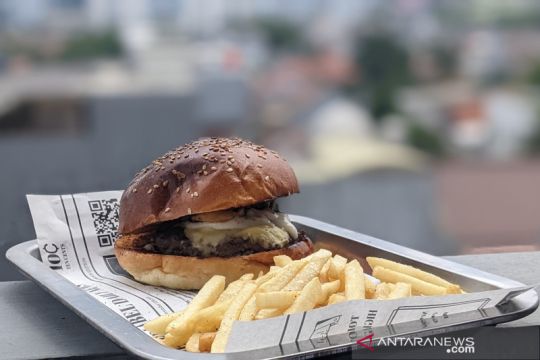 Makan burger truffle dikelilingi pemandangan gedung pencakar langit