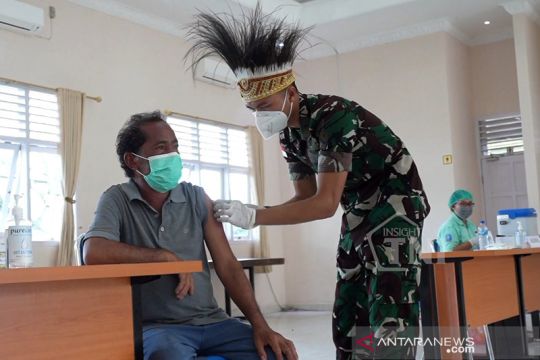 Prajurit TNI gunakan hiasan kepala khas Papua gelar vaksinasi