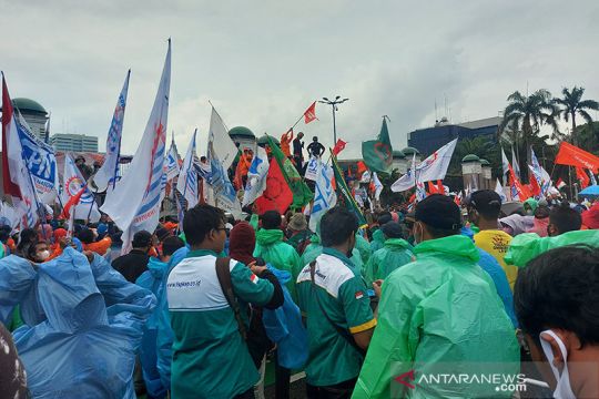 Ribuan buruh bertahan gelar aksi demo di DPR meskipun turun hujan