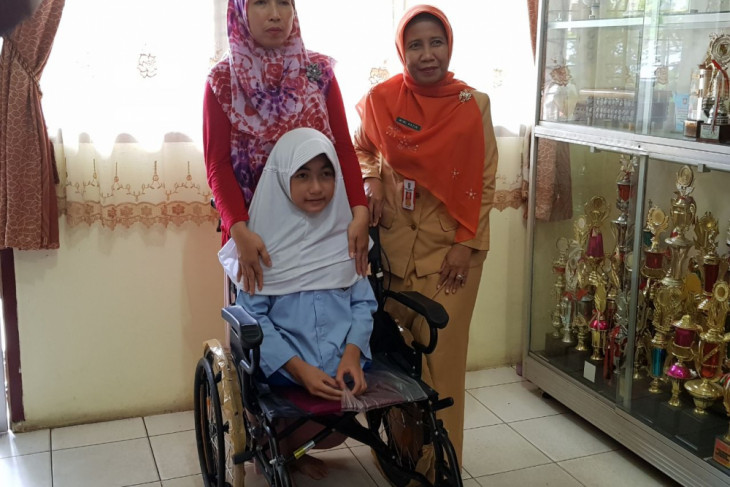 Bulan Karunia Rudianti, dengan kursi roda baru pemberian Presiden Joko Widodo, didampingi ibunya Purwanti dan Kepala Dinas Kesehatan Riau Mimi Nazir di Pekanbaru, Selasa (20/3/2018).