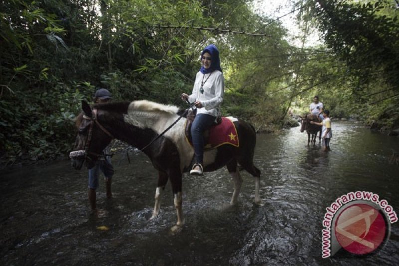 Wisatawan menysuri sungai