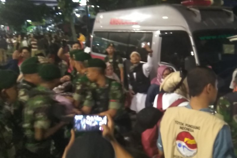Sejumlah anggota TNI evakuasi peserta aksi yang kelelahan