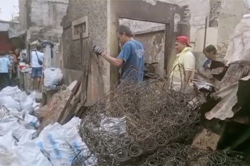 Warga membersihkan puing-puing kebakaran Tebet