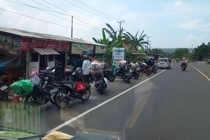 Pemudik menggunakan sepeda motor beristirahat di bahu jalan Jalinsum