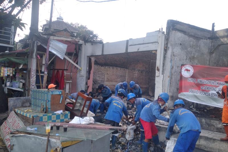 Petugas gabungan bersih-bersih di lokasi kebakaran Pasar Gembrong
