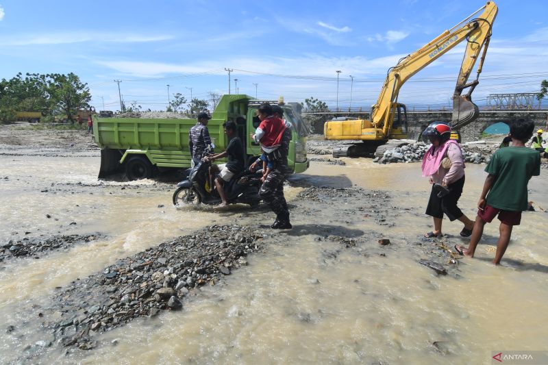 TNI BANTU MASYARAKAT DAN PEMUDIK LINTASI SUNGAI