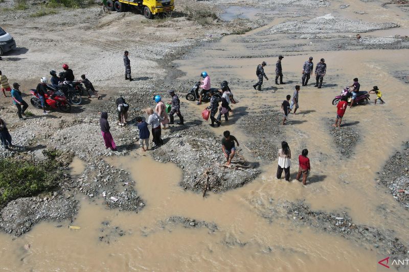 TNI BANTU MASYARAKAT DAN PEMUDIK LINTASI SUNGAI