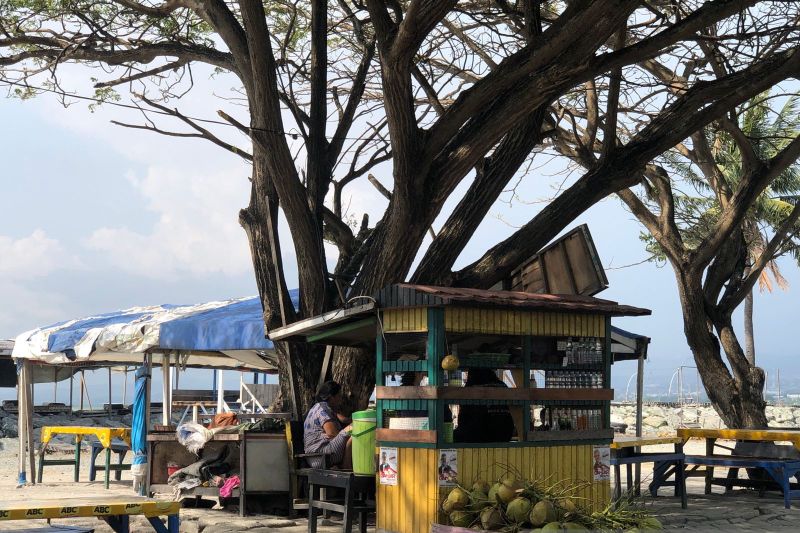 Santai di pinggiran Pantai Talise dengan minuman es kelapa yang menyegarkan