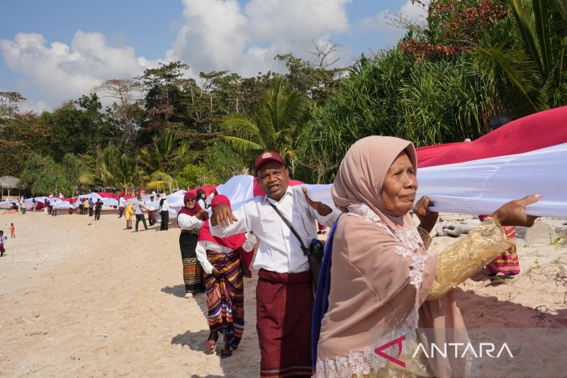 Pupuk Indonesia-Relawan Bakti BUMN bentangkan bendera sepanjang 1km